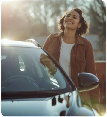 Woman smiling, leaning on a dark car.