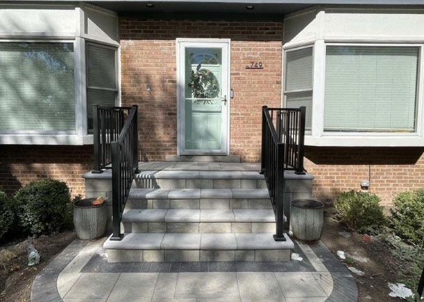 A brick house with stairs leading up to the front door