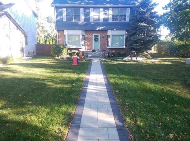 A house with a blue roof and a walkway leading to it