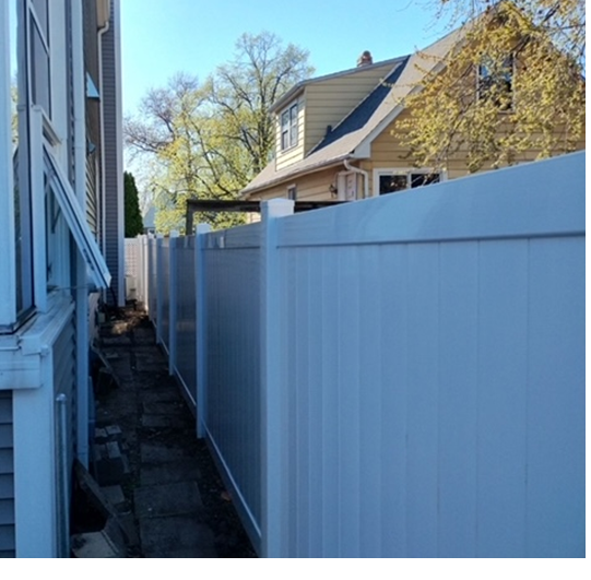 A white fence with a house in the background
