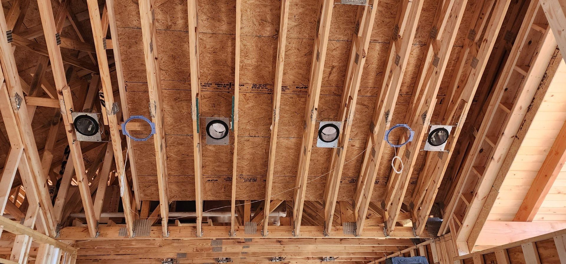 Unfinished wood ceiling with recessed light fixtures.