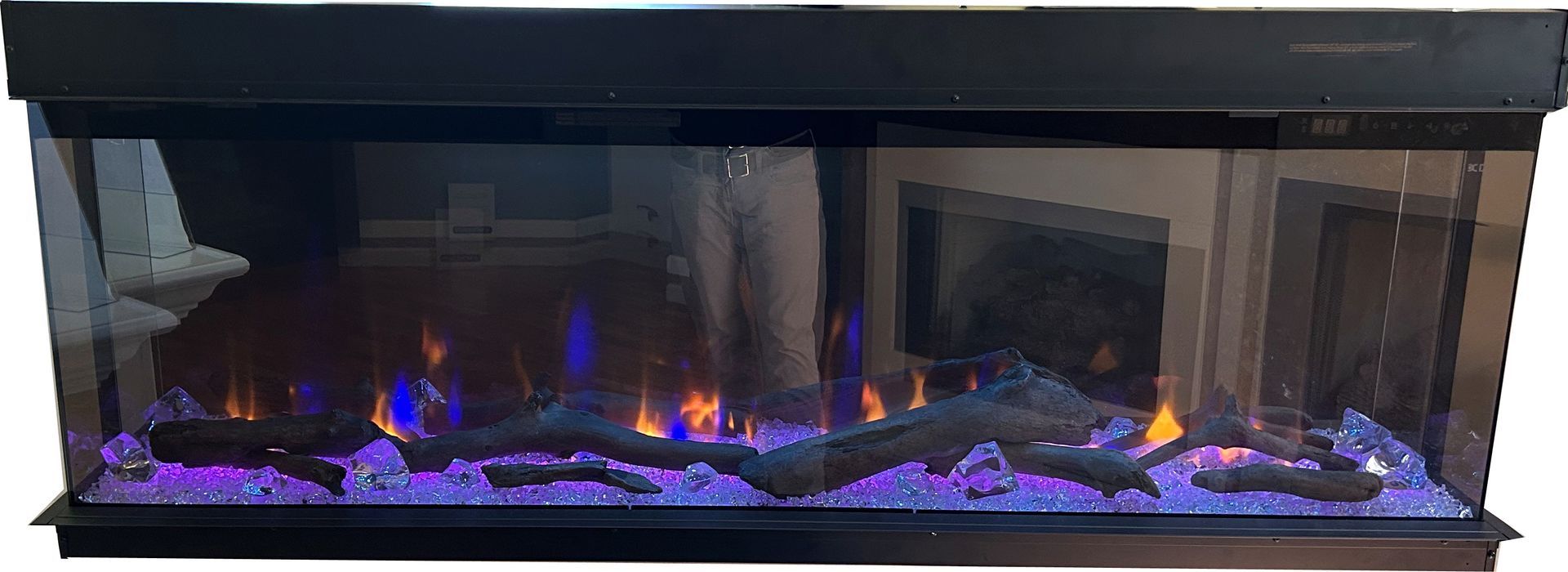 Modern black electric fireplace with blue-purple flames and glowing logs in a stone surround