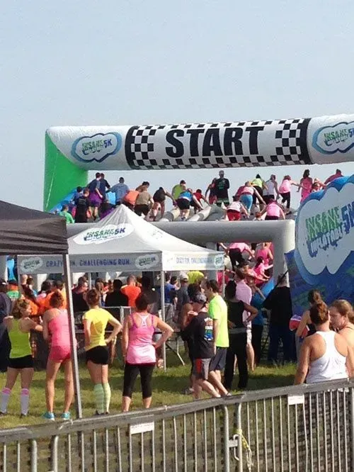 People at the start line of a race, under a large