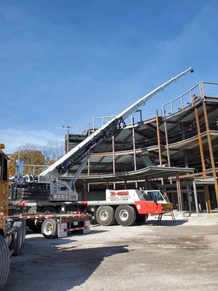 Construction site with a crane lifting steel beams for a building frame