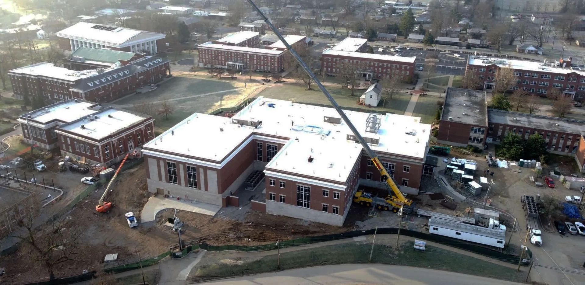 Aerial view of a construction site with buildings, cranes, and partially completed brick structures