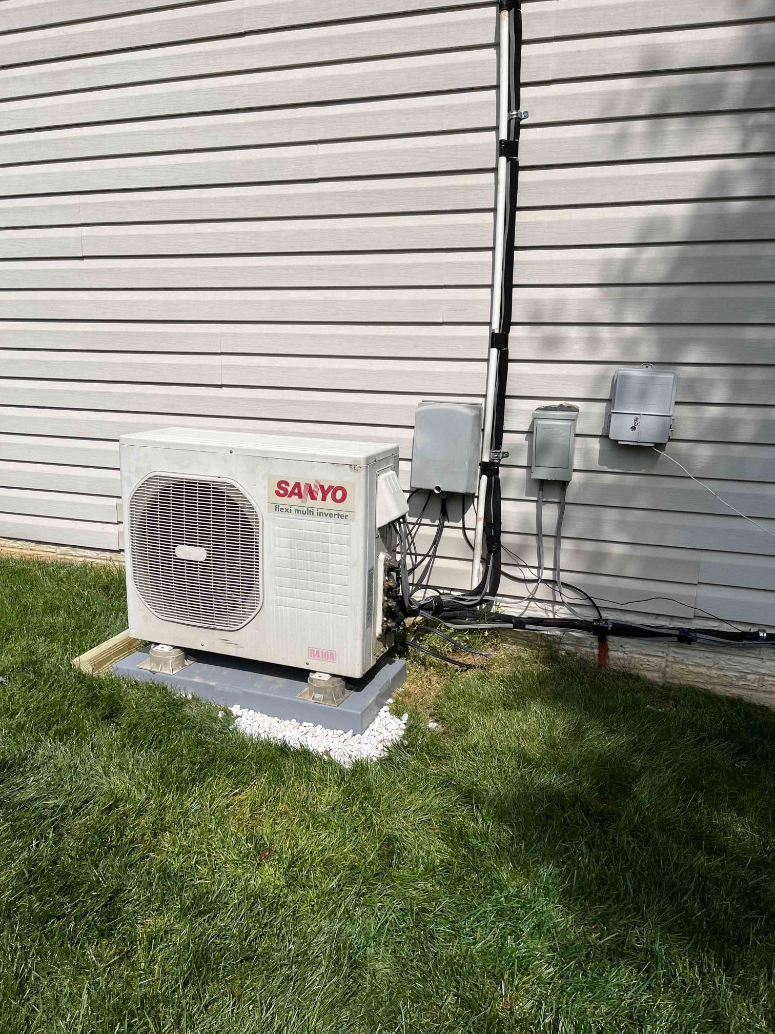 A Sanyo air conditioner installed next to a house