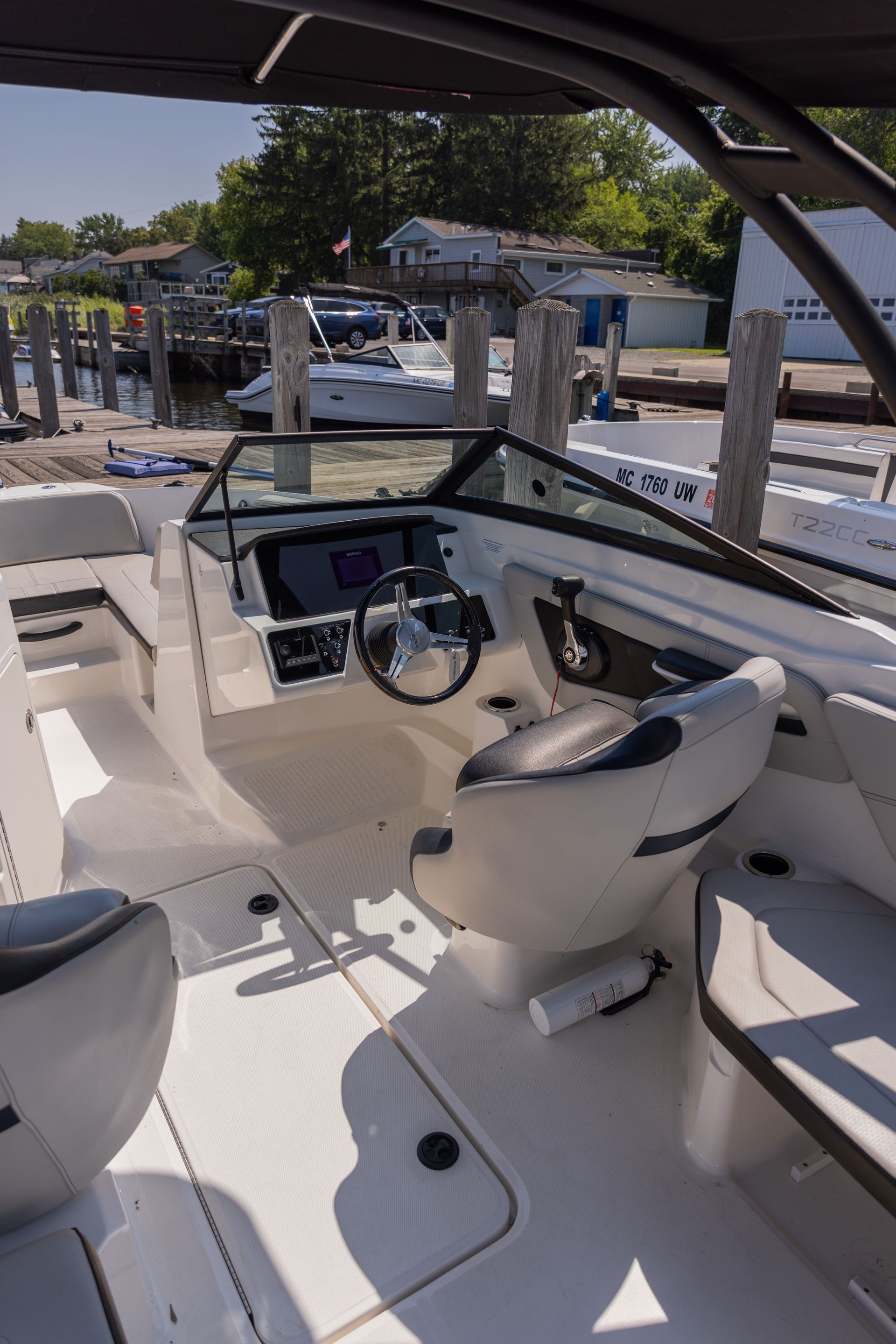 The inside of a boat with a steering wheel and seats.
