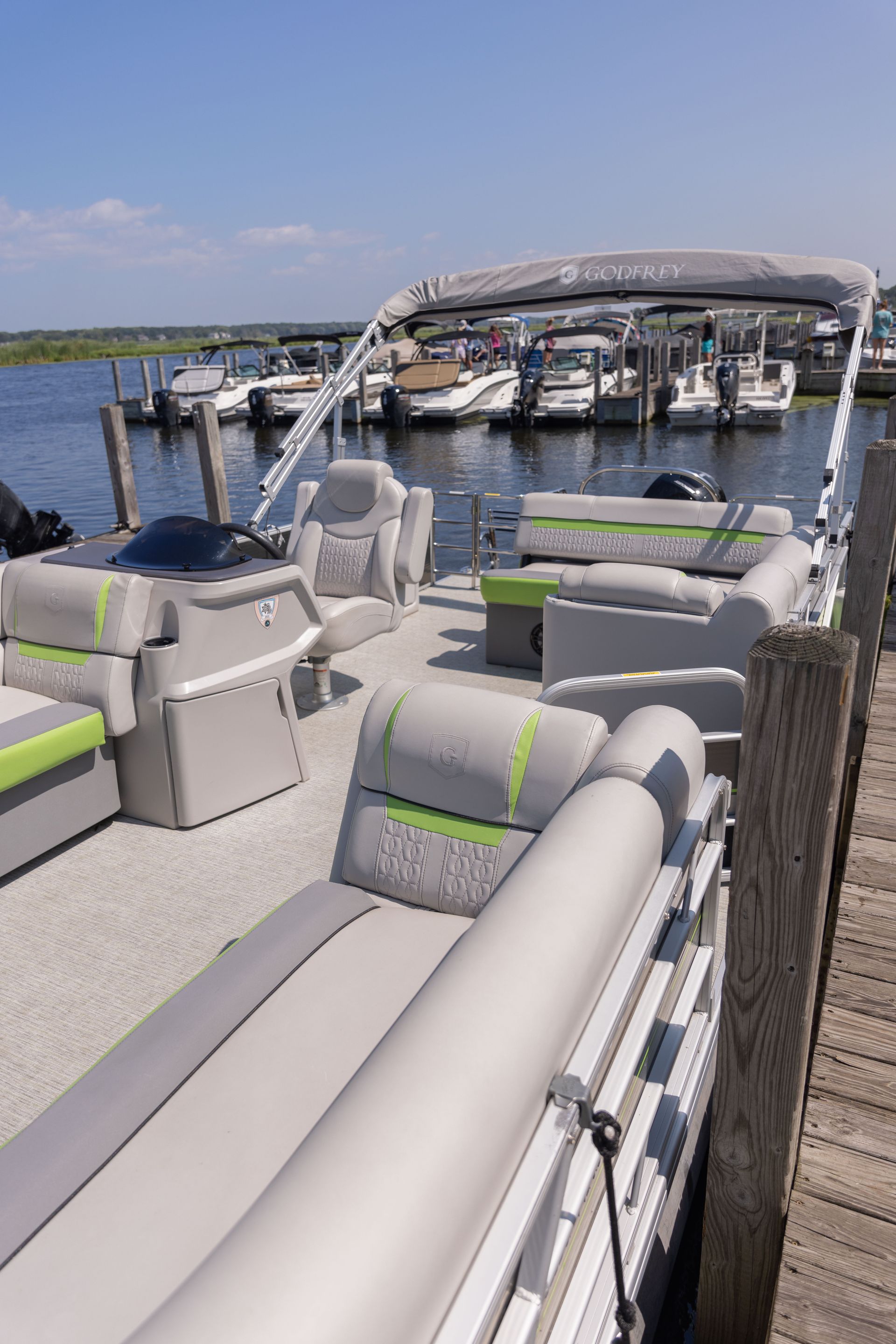 A pontoon boat is docked at a marina.