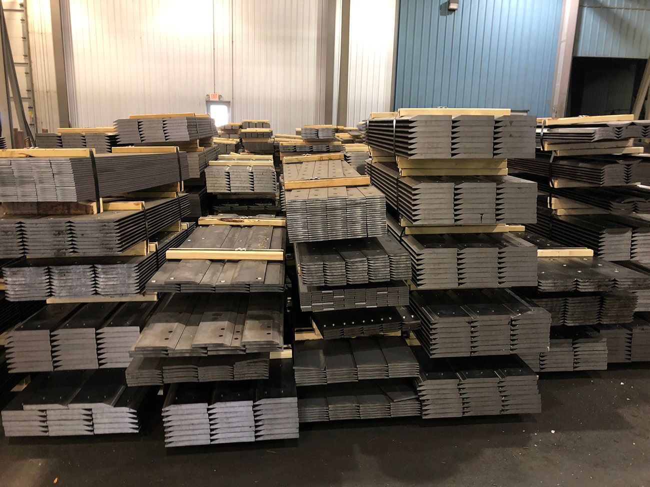 A bunch of metal rods are stacked on top of each other on a blue surface.