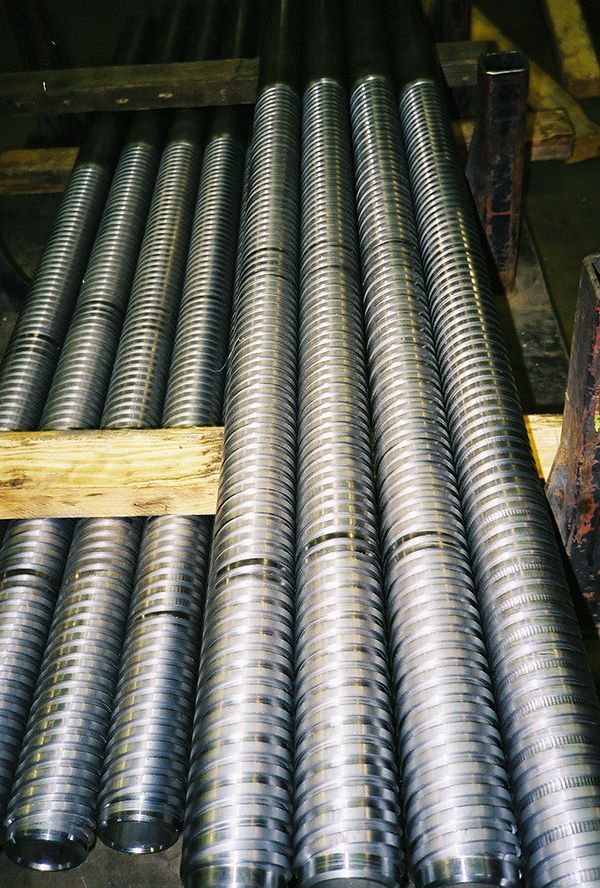 A bunch of metal rods are stacked on top of each other on a wooden pallet.