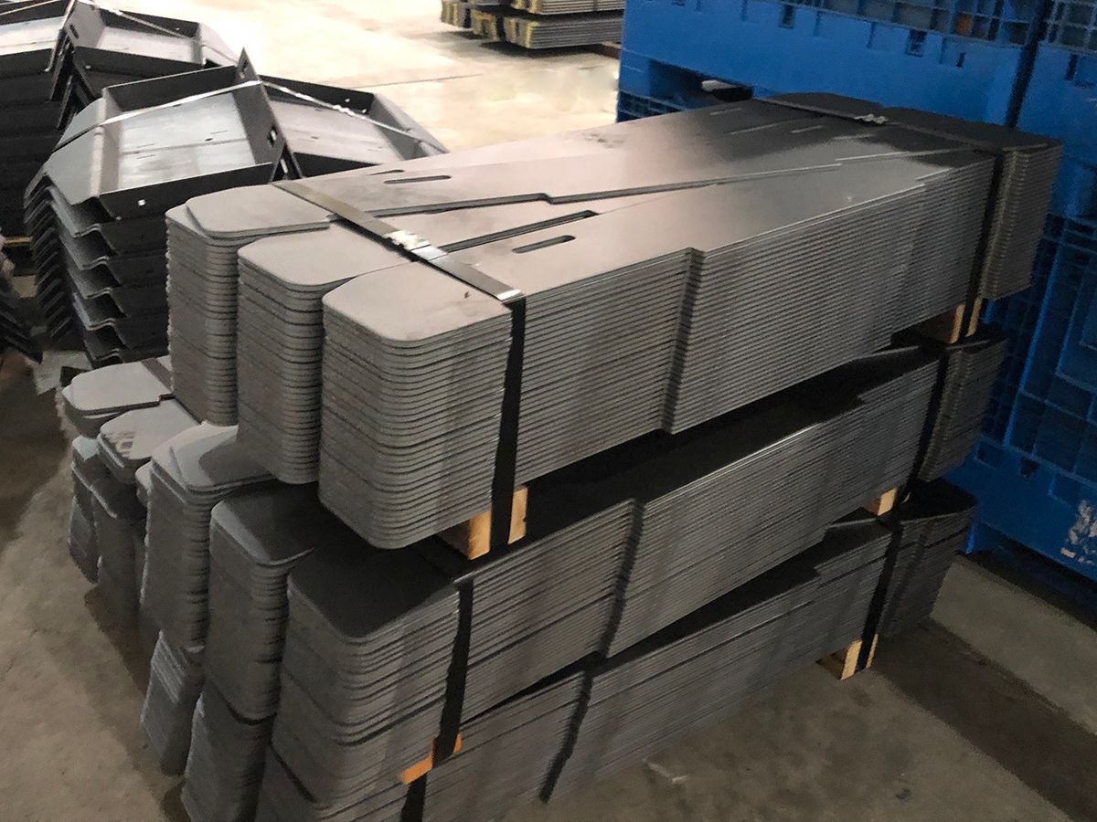 A stack of metal sheets sitting on top of each other in a warehouse.