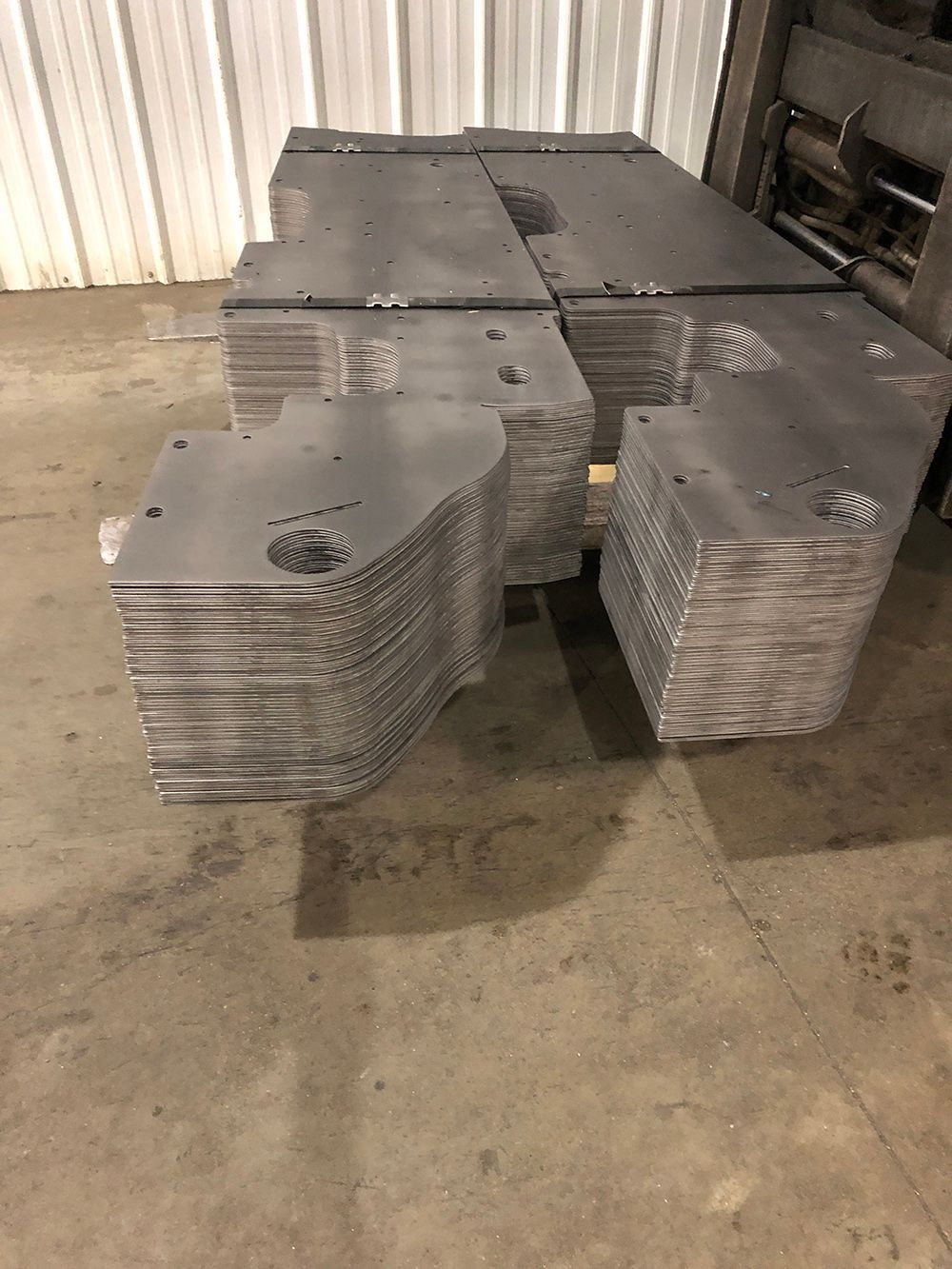 A stack of metal plates sitting on top of each other on a concrete floor.