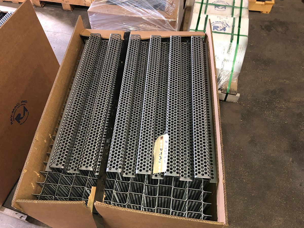 A cardboard box filled with a bunch of metal pieces