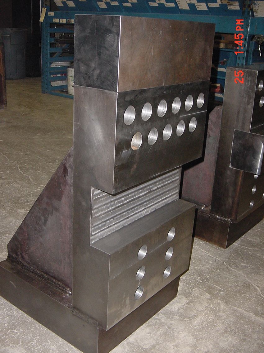 A piece of metal with holes in it is sitting on the floor