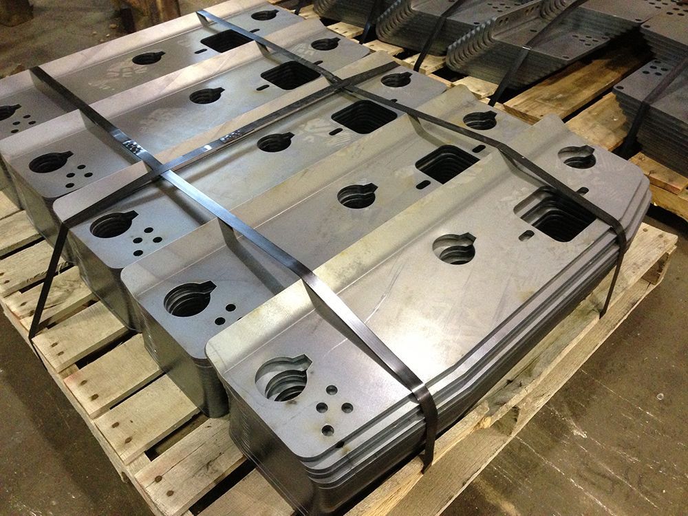 A wooden pallet filled with a bunch of metal pieces.