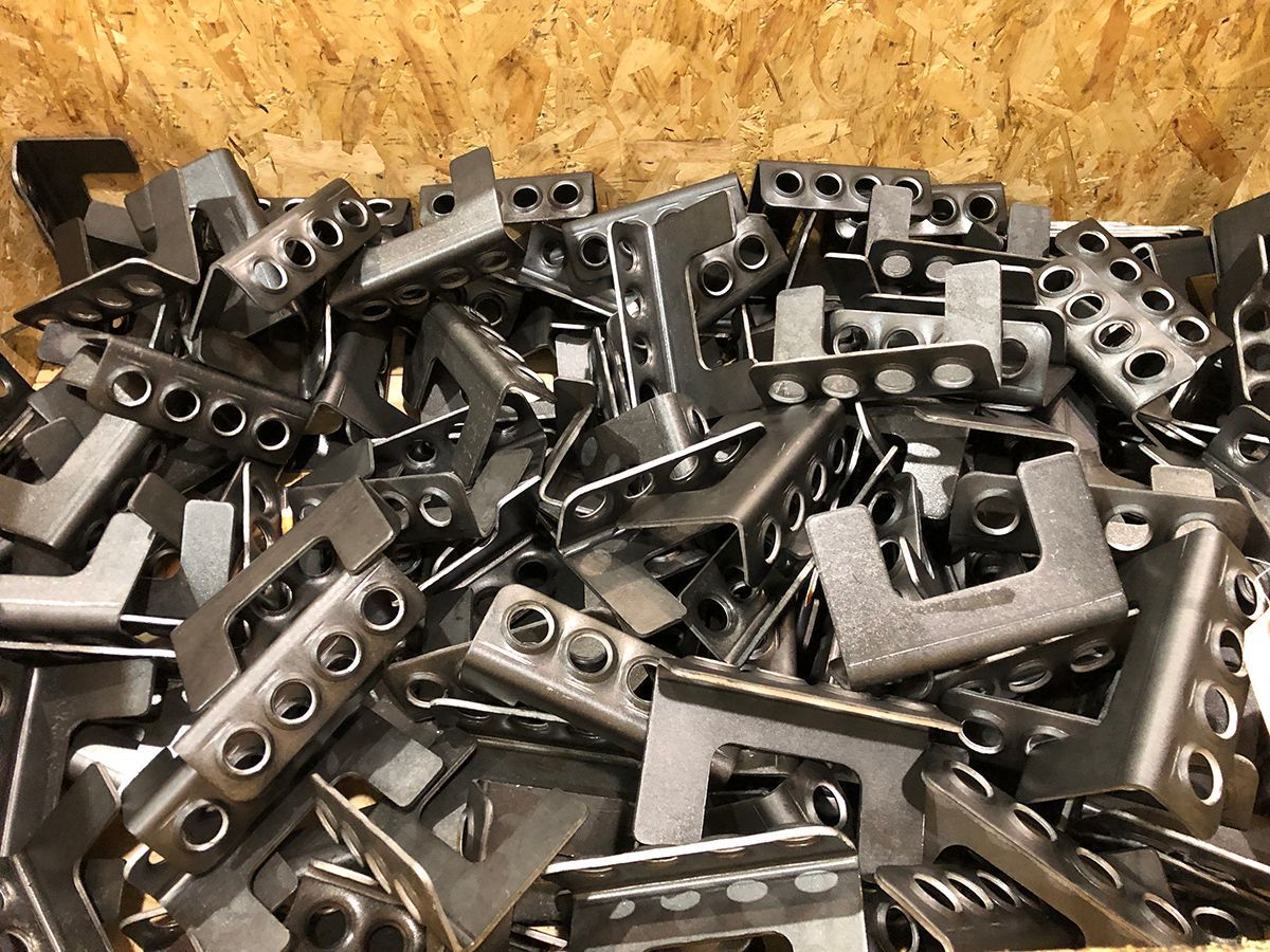 A pile of metal parts sitting on top of a wooden table.