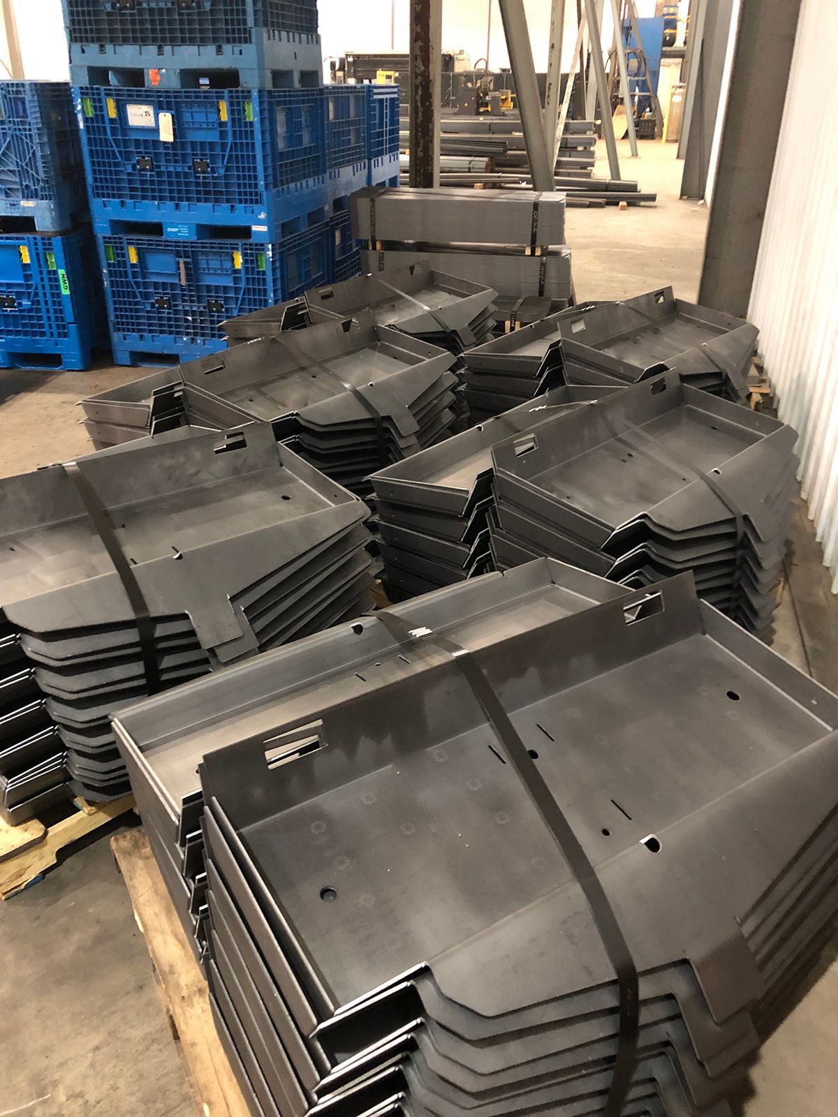 A bunch of metal pieces are stacked on top of each other in a warehouse.