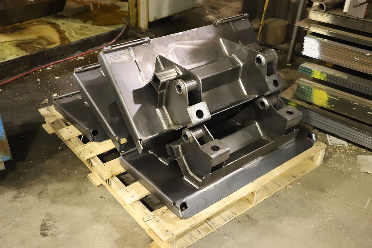 A piece of metal is sitting on top of a wooden pallet.