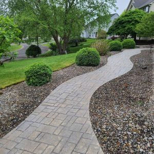 A brick walkway leading to a house in a residential area.