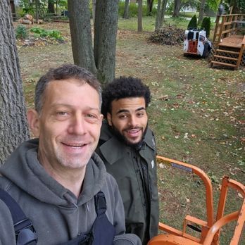 Two men are standing next to each other in a park.
