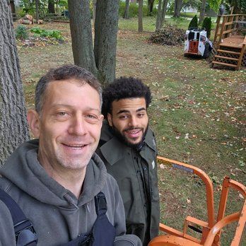 Two men are standing next to each other in a park.