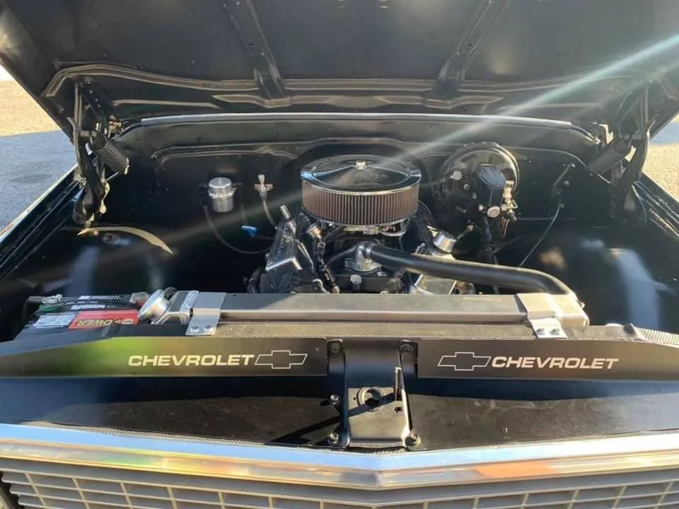 Black Chevrolet pickup truck engine compartment with a chrome air cleaner.