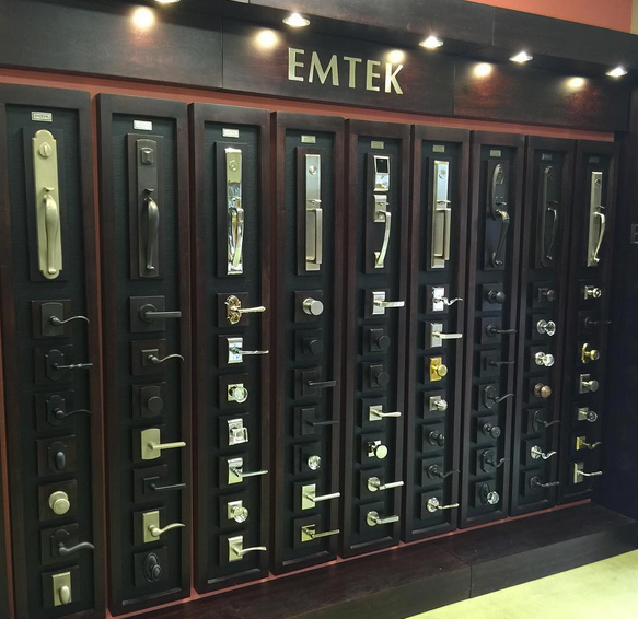 Row of black door and window display panels with various handles and locks under the sign “EMTER”