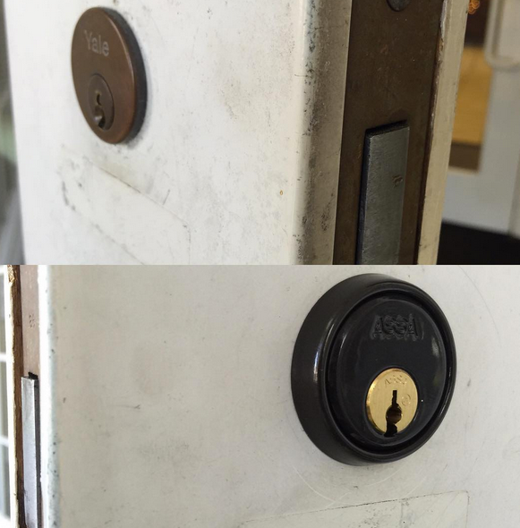 Close-up of a round black deadbolt lock on a white door