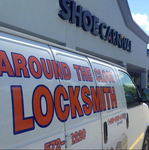 Van with large orange “LOCKSMITH” ad parked outside Shoe Carnival storefront
