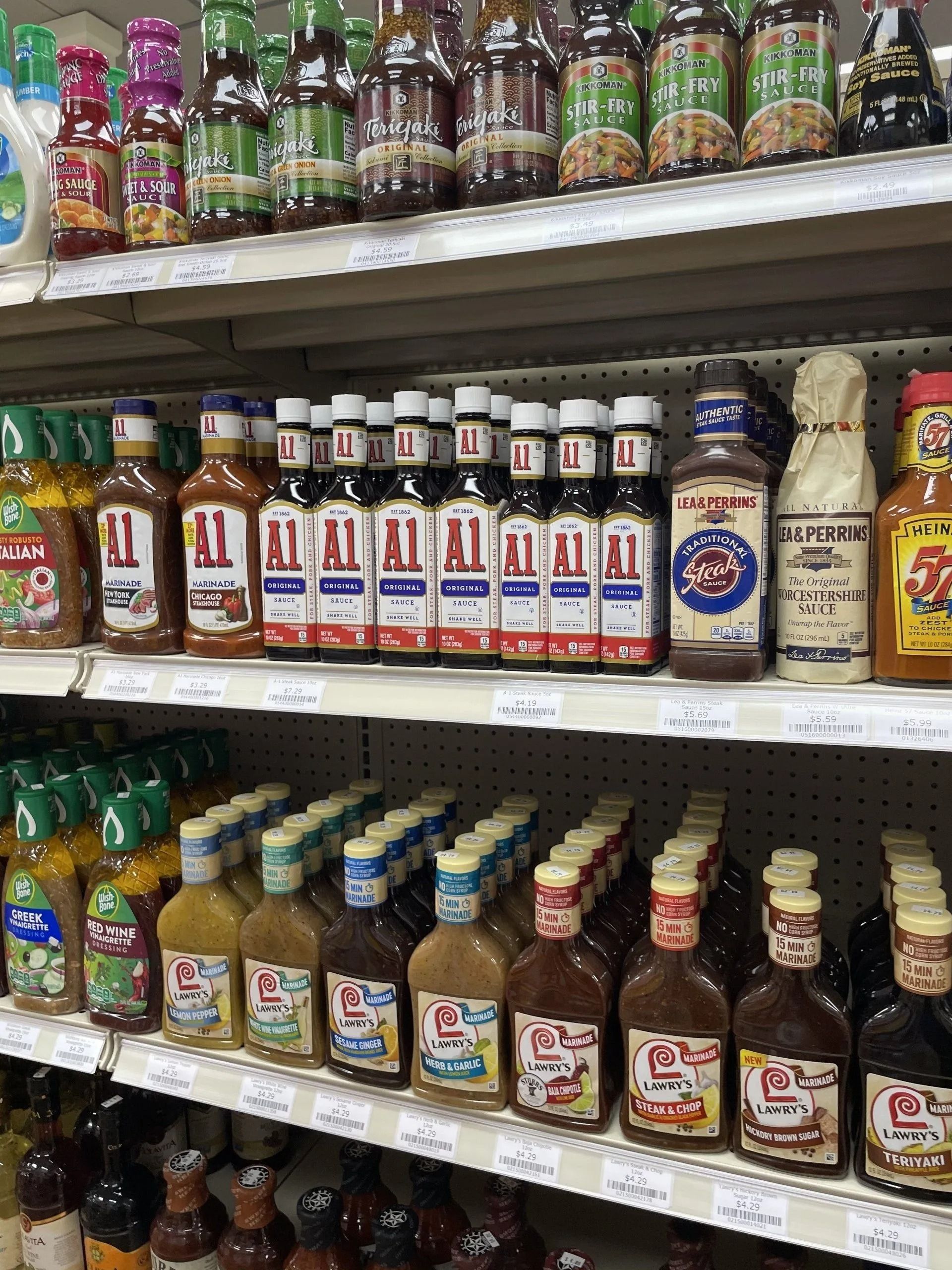 Shelves stocked with various sauce bottles in a grocery store.
