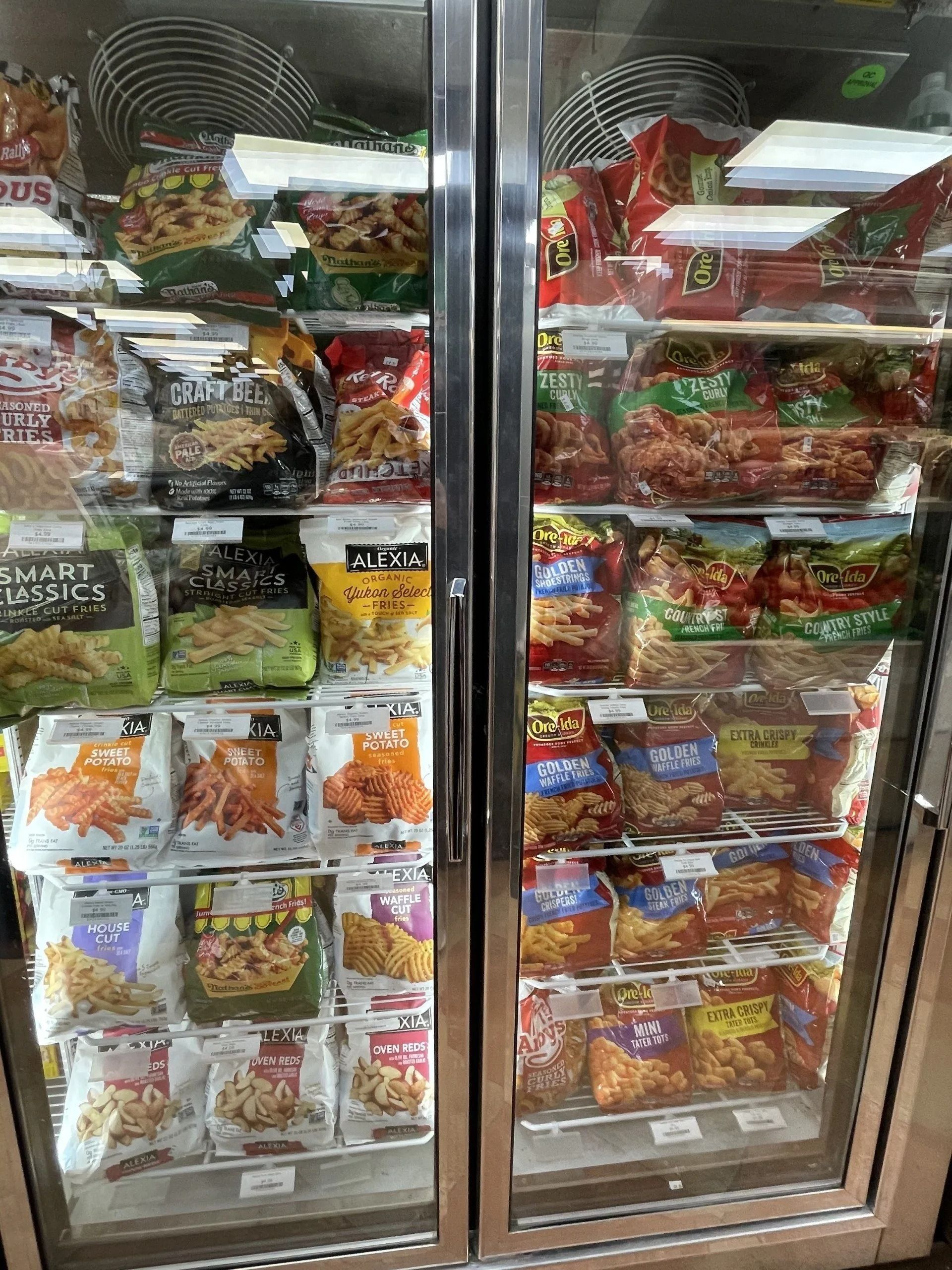 Two glass-door freezer displaying various frozen food bags.
