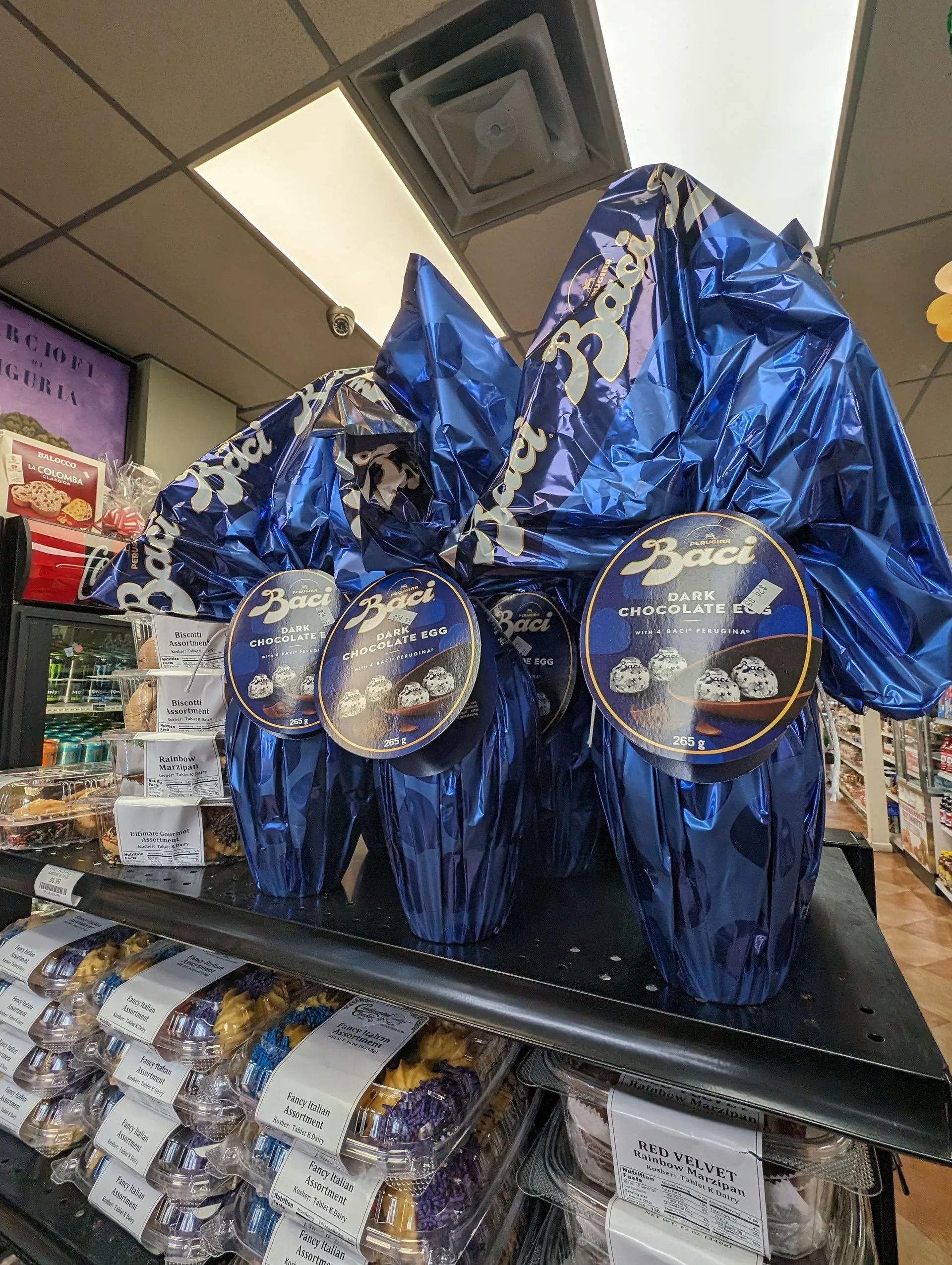 Shelf display of wrapped blue Easter eggs in a store setting.
