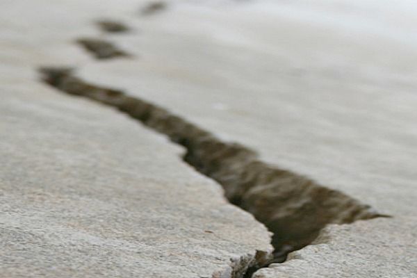 Crack in a light-colored surface with a blurred background, suggesting potential damage or disruption.