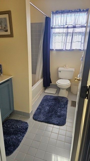 A bathroom with a toilet , sink , and shower.