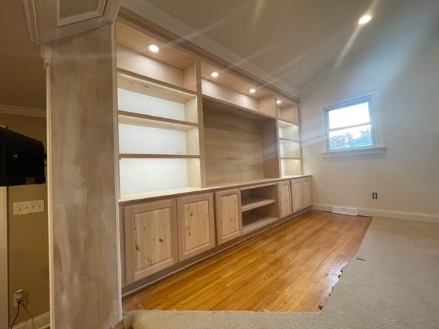 A room with a lot of shelves and a window