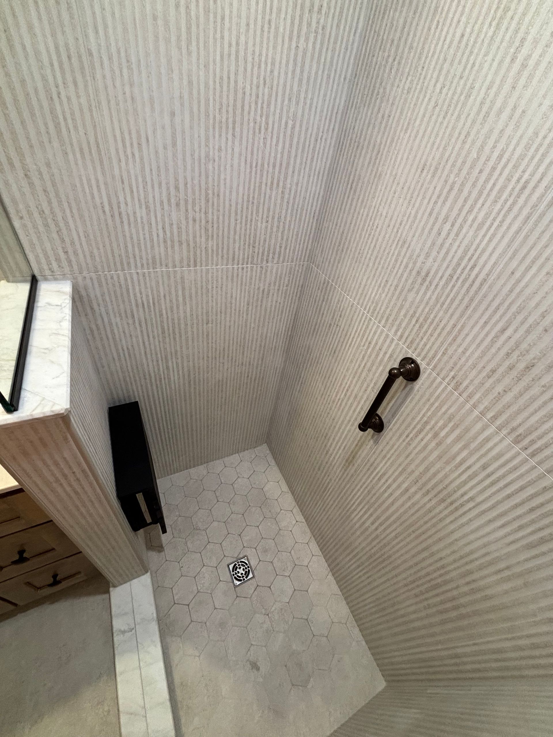 A bathroom with a walk in shower and a mirror.