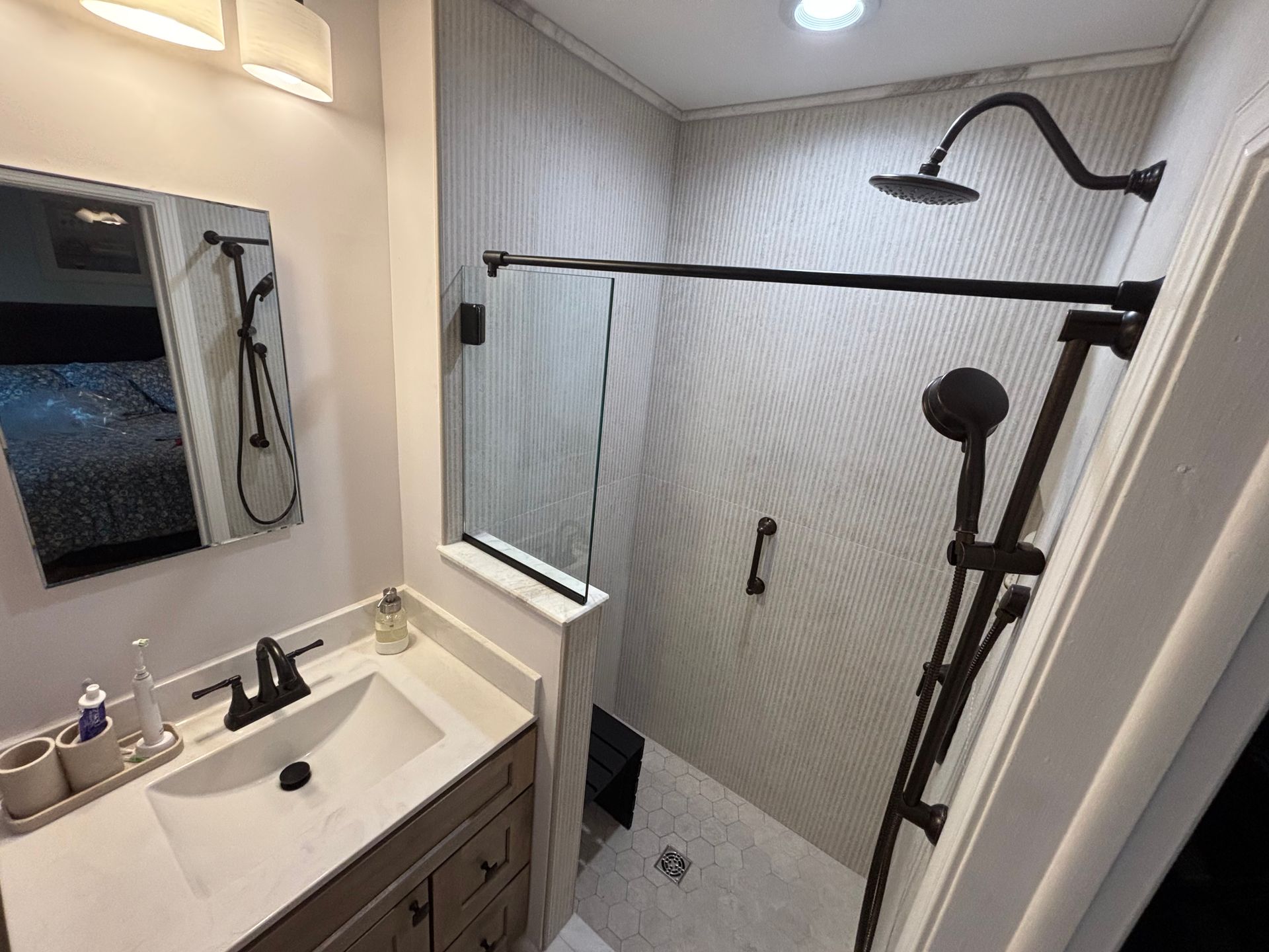 A bathroom with a sink and a walk in shower.