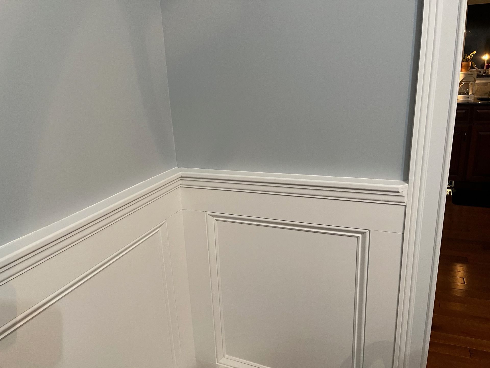A corner of a room with gray walls and white trim.