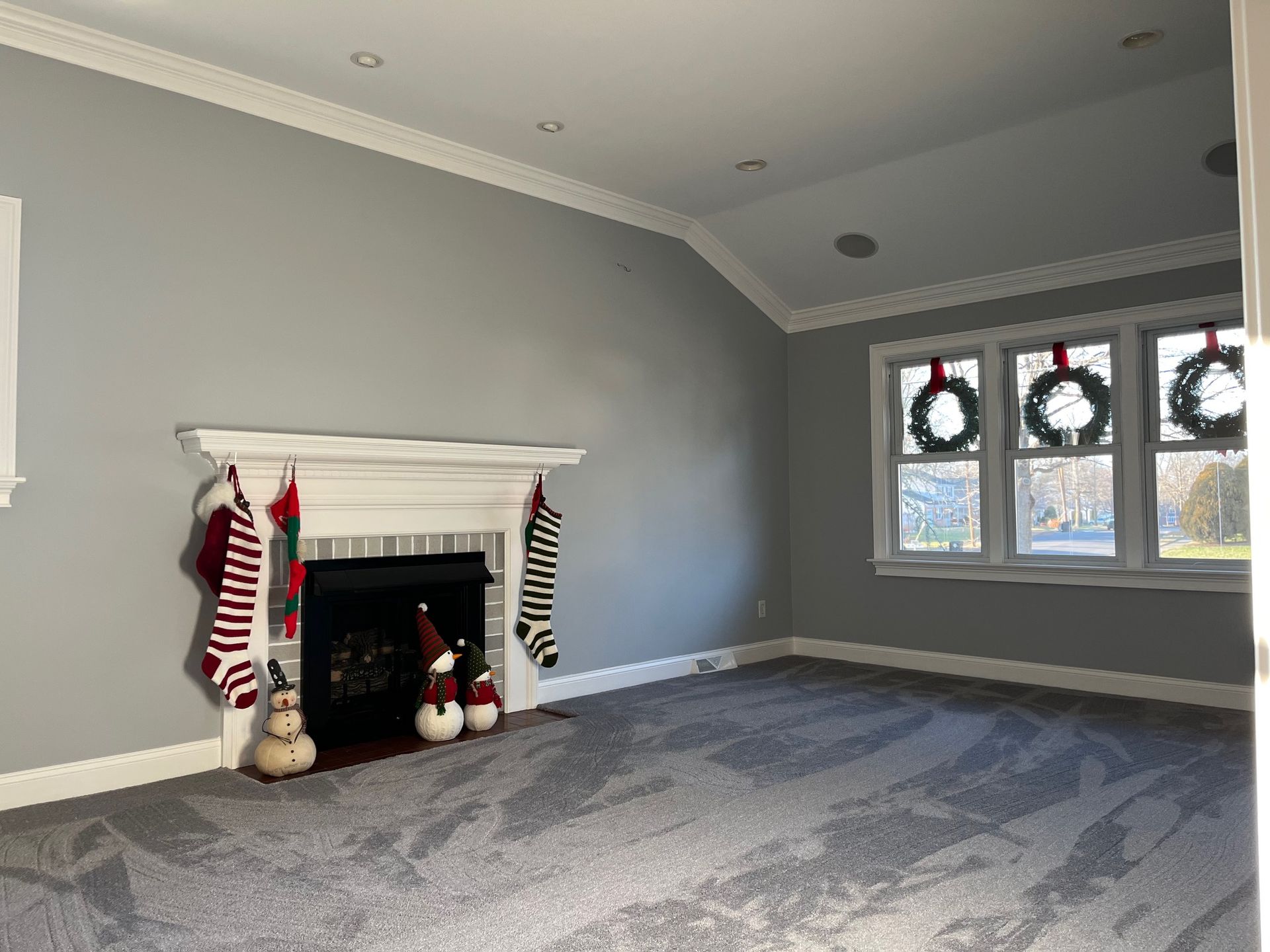 A living room with a fireplace and christmas stockings on the mantle.