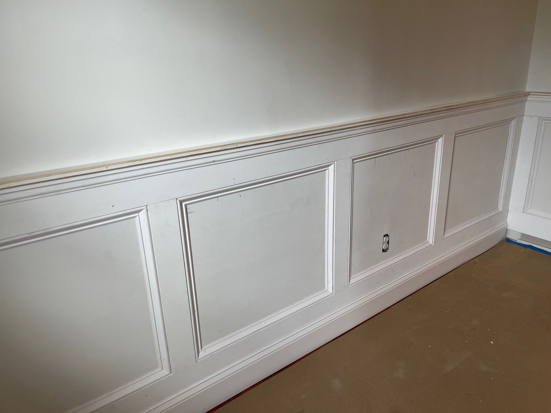 A white wall with a row of cabinets underneath it.
