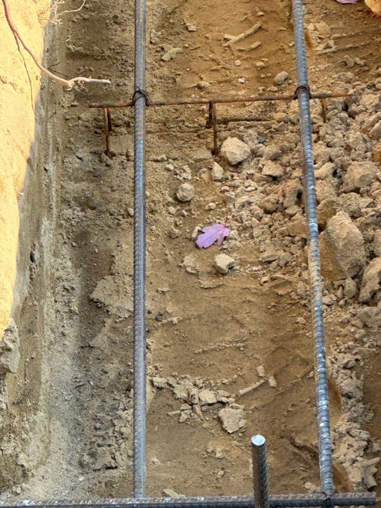A bunch of metal bars are sitting on top of a pile of dirt.