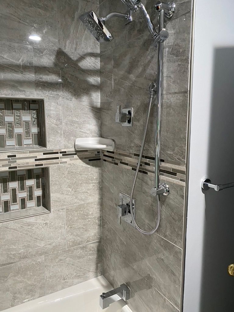 A bathroom with a tub and a shower head.