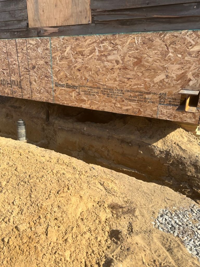A pile of sand is sitting next to a wooden structure.