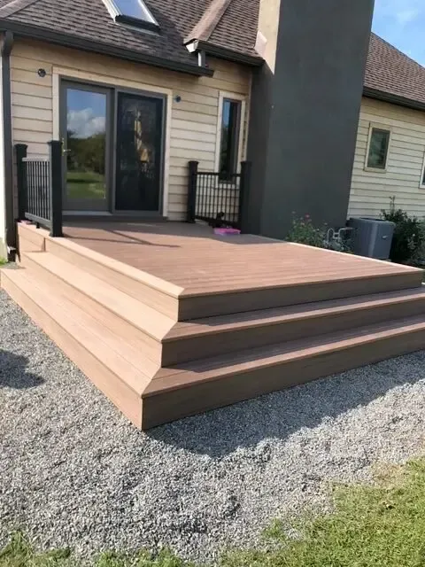 A wooden deck with stairs in front of a house
