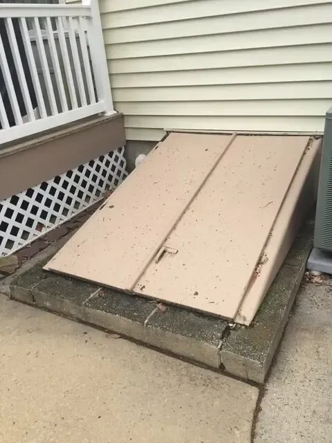 A wooden ramp is sitting on a sidewalk next to a house