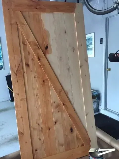 A large wooden door is sitting on a table in a garage