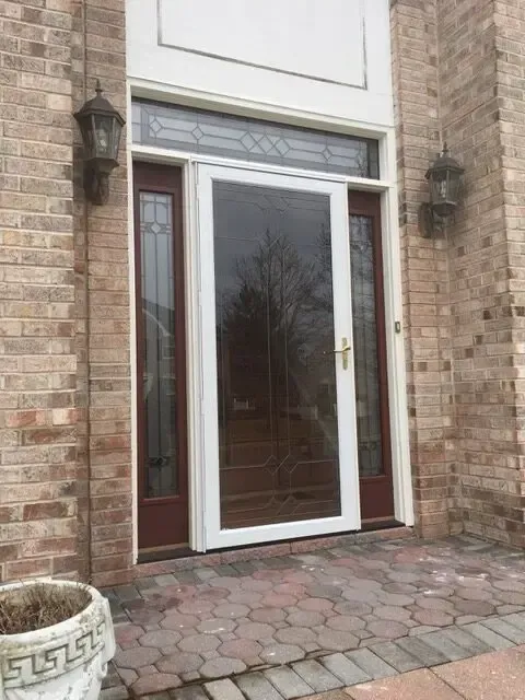 A brick building with a white door and a potted plant in front of it.