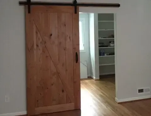 There is a sliding barn door in the middle of a room.