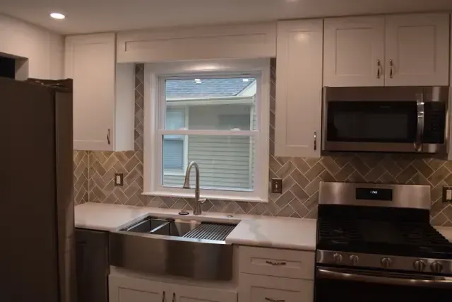 A kitchen with stainless steel appliances and white cabinets