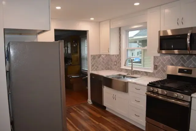 A kitchen with stainless steel appliances and white cabinets